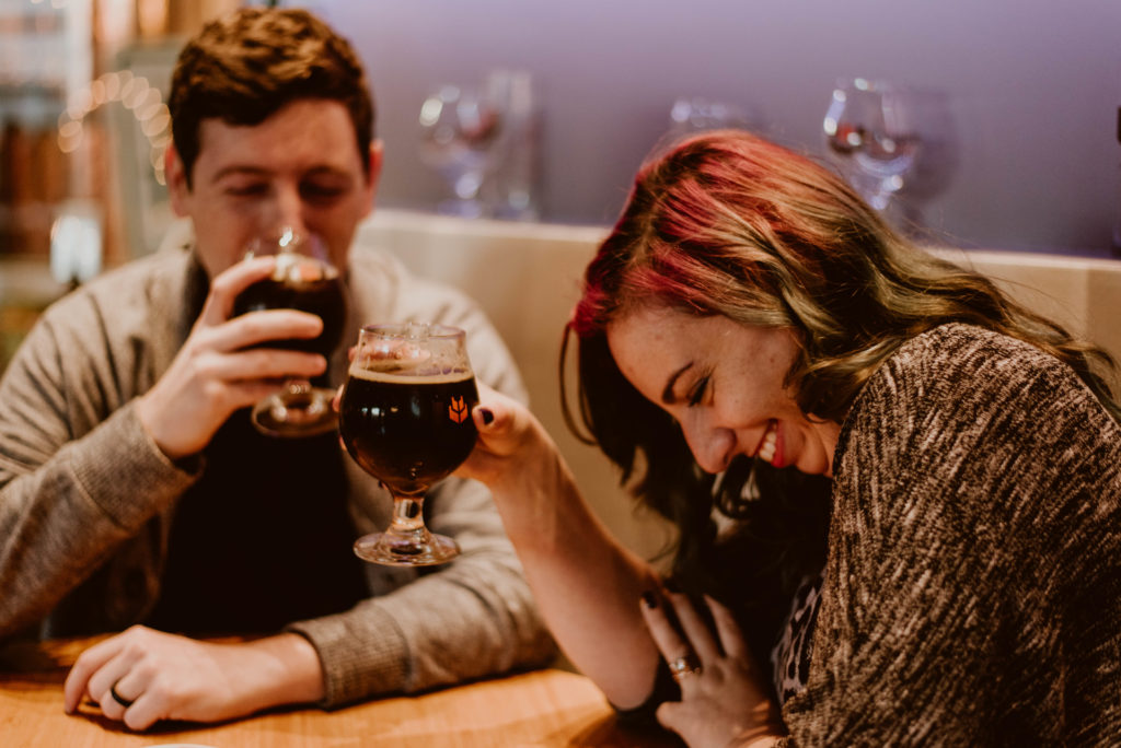 Couple laughing over a beer. Read on to find out the best ways to make your photo session awesome!