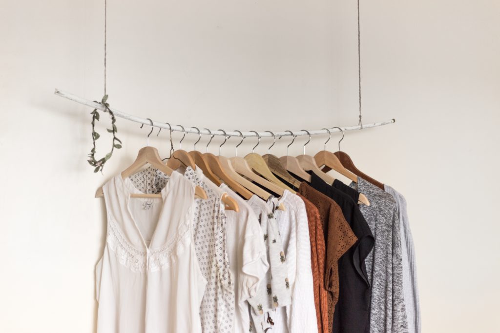Clothes hanging on a rack. Read this post for tips about how to downsize into a tiny home!