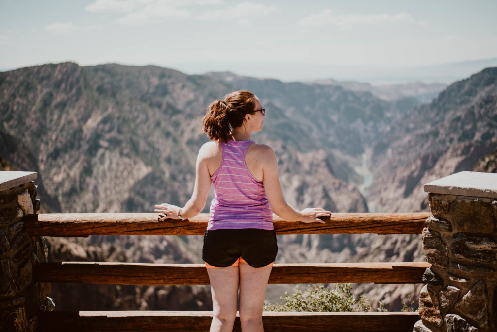 Girl standing and looking out at a canyon during travels. Find out the one thing that is most valuable to take with you as a guide during your travels.