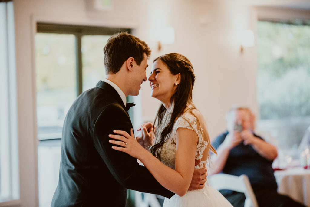 A bride and groom laugh and look at each other during their first dance. Check out this post for more photos from Emma + Taylor's summer Santa Rosa wedding!