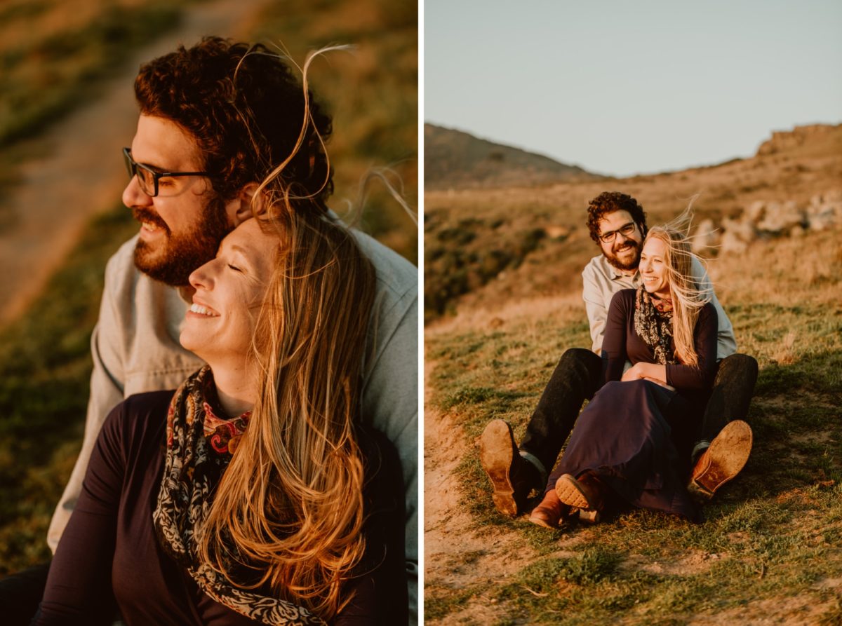 A couple embrace and sit on the Sonoma coast as they watch the sunset.