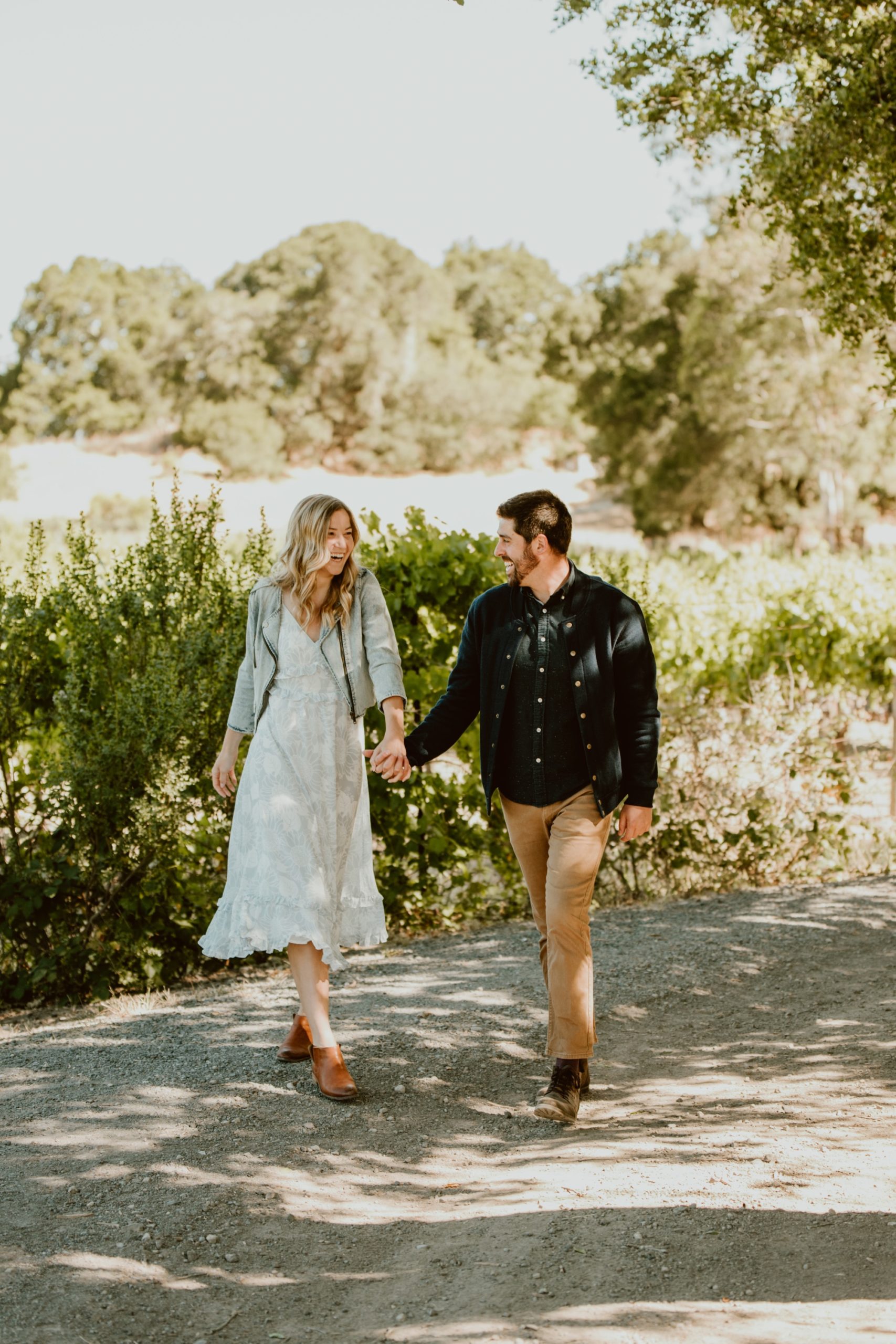 A couple strolls hand in hand in Jack London State Park for their engagement session.
