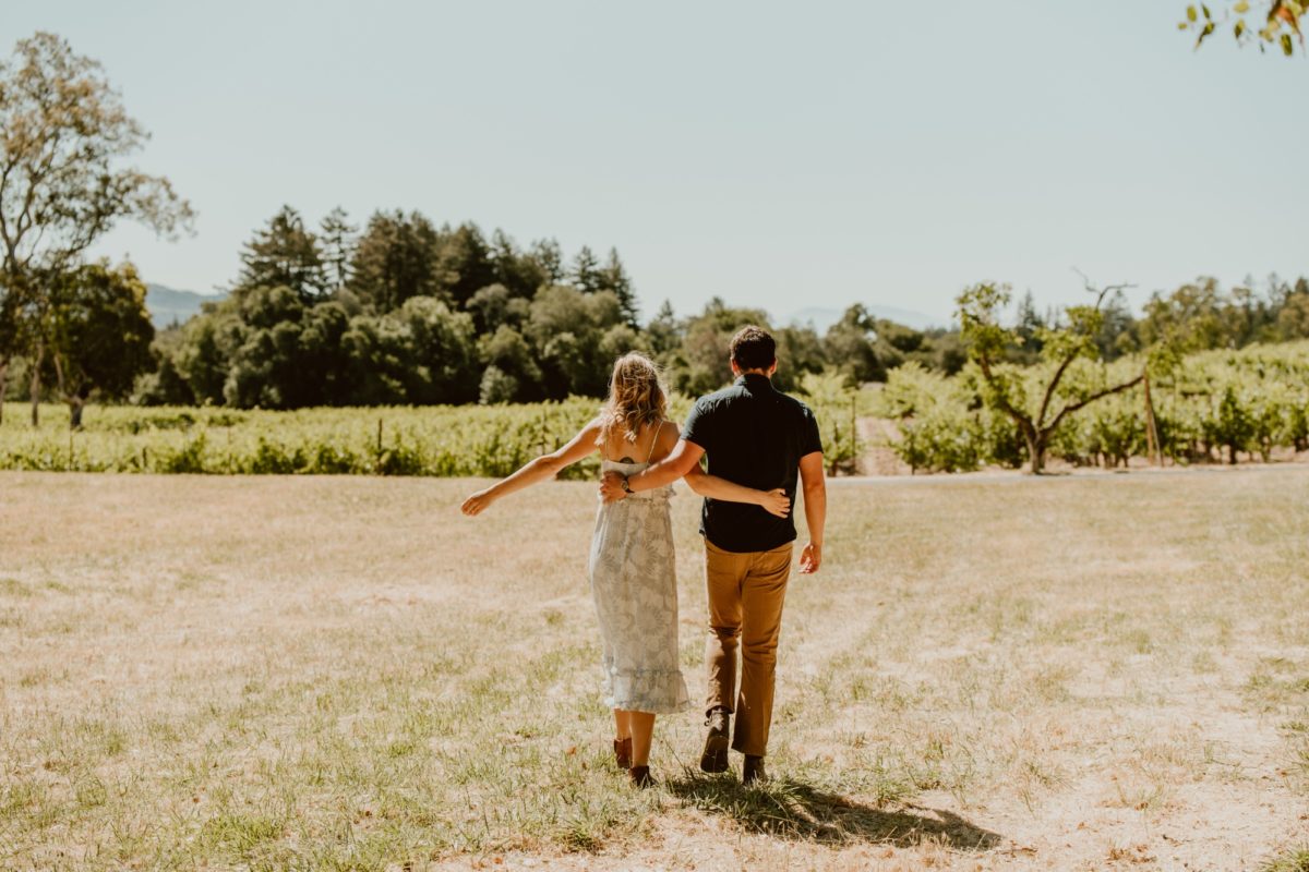 A couple strolls arm in arm in Jack London State Park for their engagement session.
